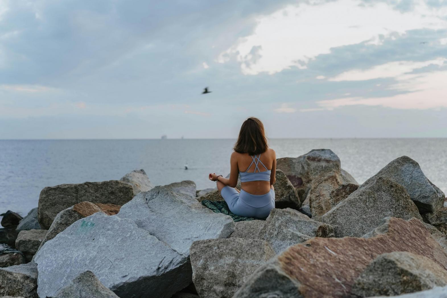 Sesión de yoga corporativo en oficina moderna con empleados practicando posturas de relajación